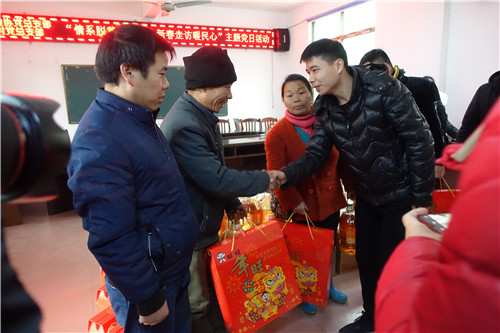 17、广西融水华林木业有限公司总经理陈丞聪(右一)慰问安陲乡吉曼村贫困群众(赖群超 摄影)
