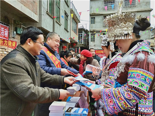 1、自治县政协副主席孔庆军(左二)、赖苗(左一)向群众发放法律知识读本(赖晓梅 摄影)