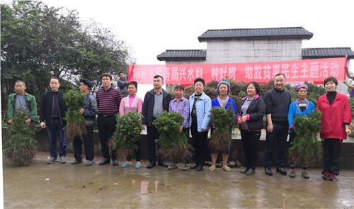 5、柳州市税务局副局长周秋容(右六)、融水苗族自治县政协副主席贾寒春(右四)与获赠树苗的贫困群众合影
