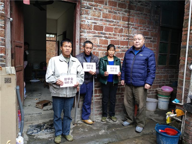 3、2017年11月24日,融水苗族自治县政协副主席孔庆军(右一)到永乐镇毛潭村西毛潭屯为帮扶联系户贫困学生发放助学金