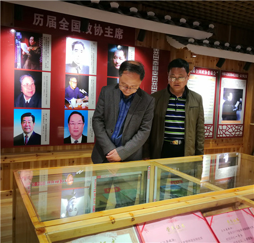 3、三江侗族自治县政协副主席赖忠厚(左)向融水苗族自治县政协副主席赖苗(右)介绍三江政协文史馆建设情况