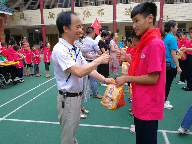 5、自治县政协机关党组书记、提案委主任吴卫斌(右一)等给残疾儿童发放节日礼物(赖群超 摄影)