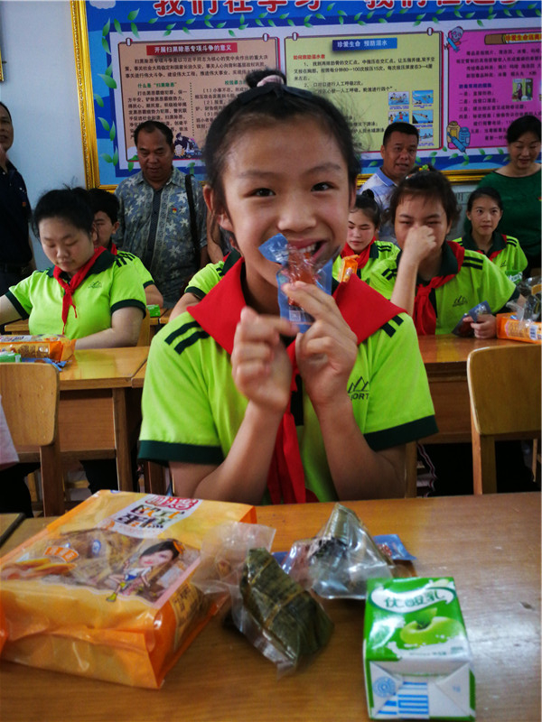 12、学生们高兴的吃着叔叔阿姨们送的小食品(赖群超 摄影)