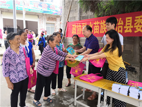 3、融水政协经济联谊委主任杨美琼(右一)向群众主发放宣传资料(廖善貌 摄影)