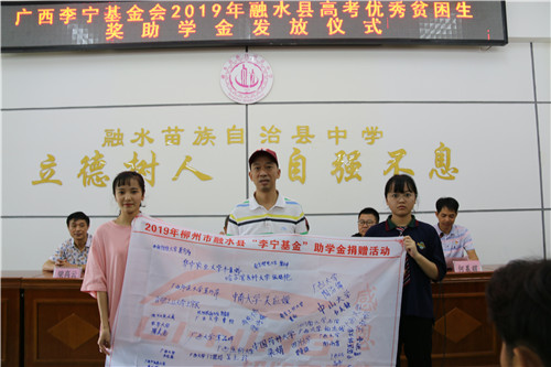 4、广西李宁基金会副秘书长、融水县政协委员林志强(中)代表广西李宁基金会接受学生签名