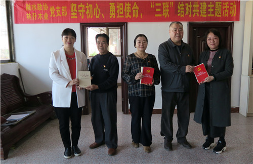 自治县政协副主席孔庆军(右二),自治县秘书长、办公室主任、政协党支部书记赖晓梅(左一)向林升公司党支部党员赠送学习资料